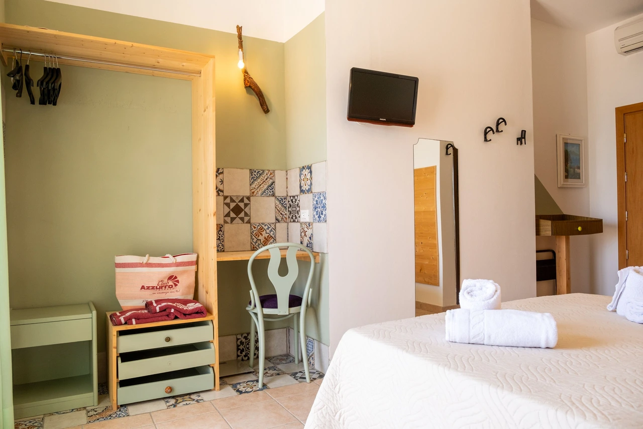 Interior de quarto de hospedagem com cama e móveis; fotografia ilustrativa.