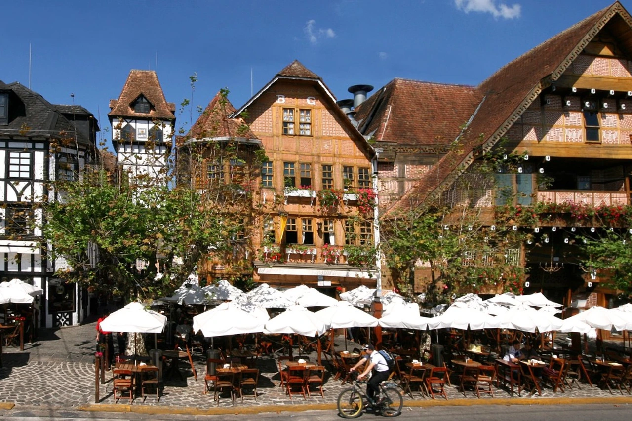 Fachada do Boulevard Genève, com mesas e guarda-sóis na calçada, na Vila Capivari, em Campos do Jordão.