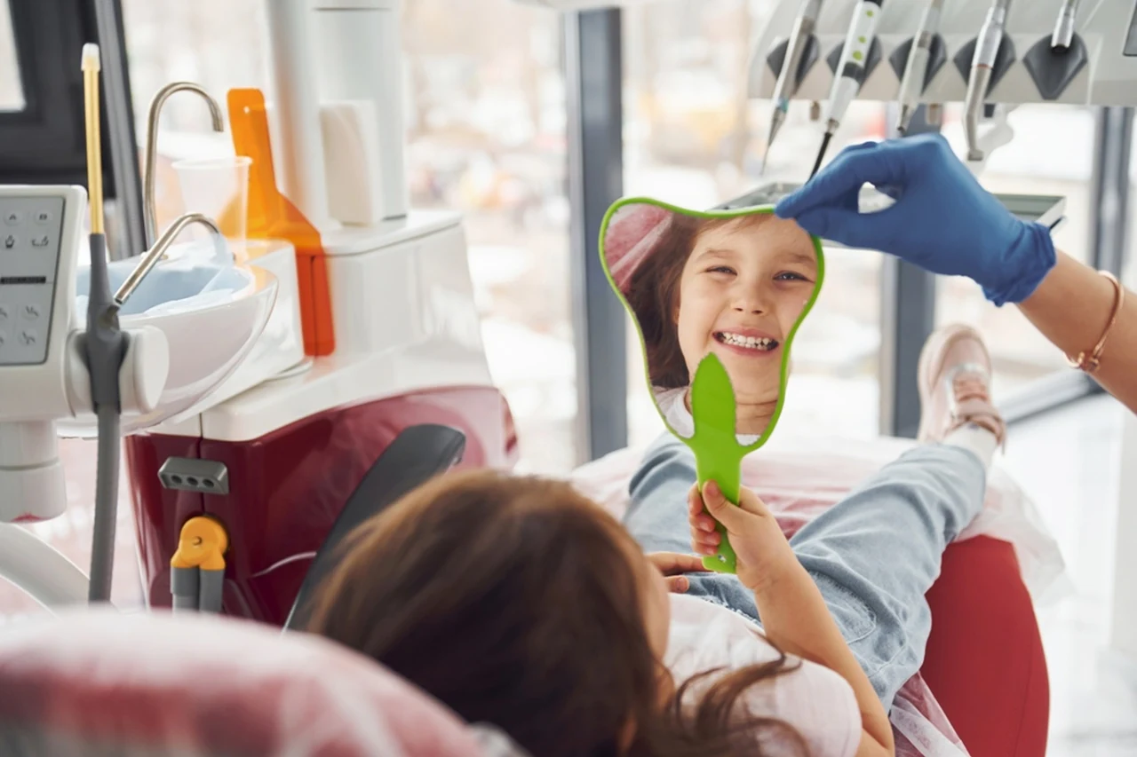 Criança observa os dentes em um espelho durante atendimento odontológico.