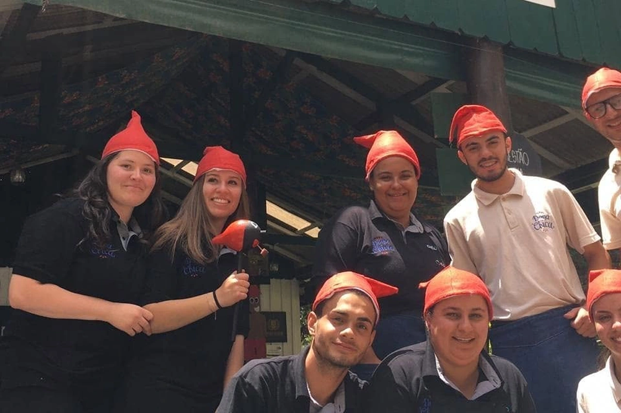 Equipe do Dona Chica com gorros vermelhos na entrada do restaurante.