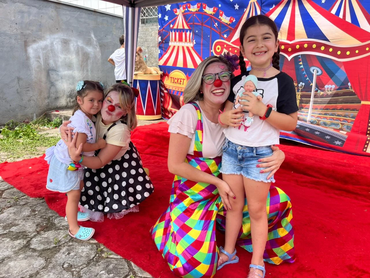 Crianças com personagens em espaço decorado para a festa.