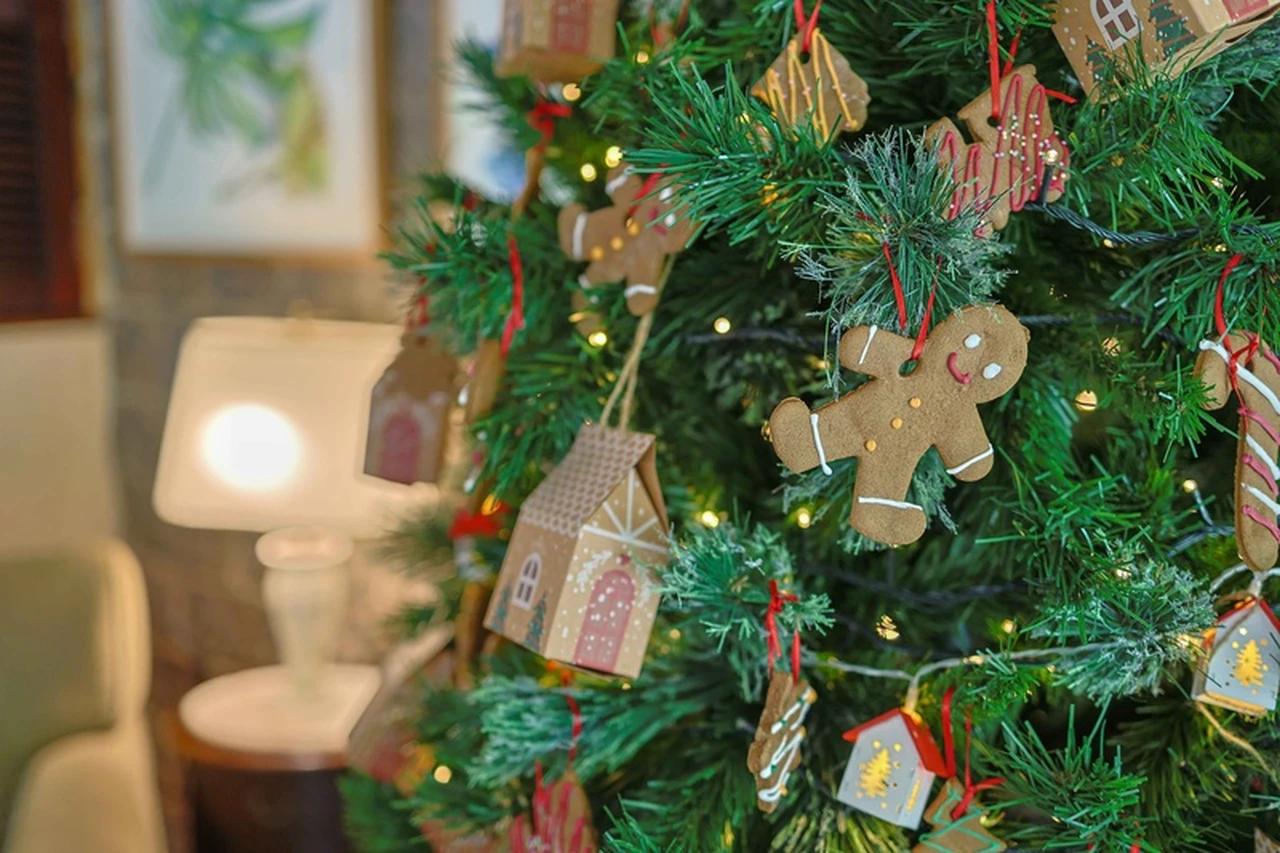 Biscoitos em formatos de boneco e casinhas pendurados em uma árvore de Natal.