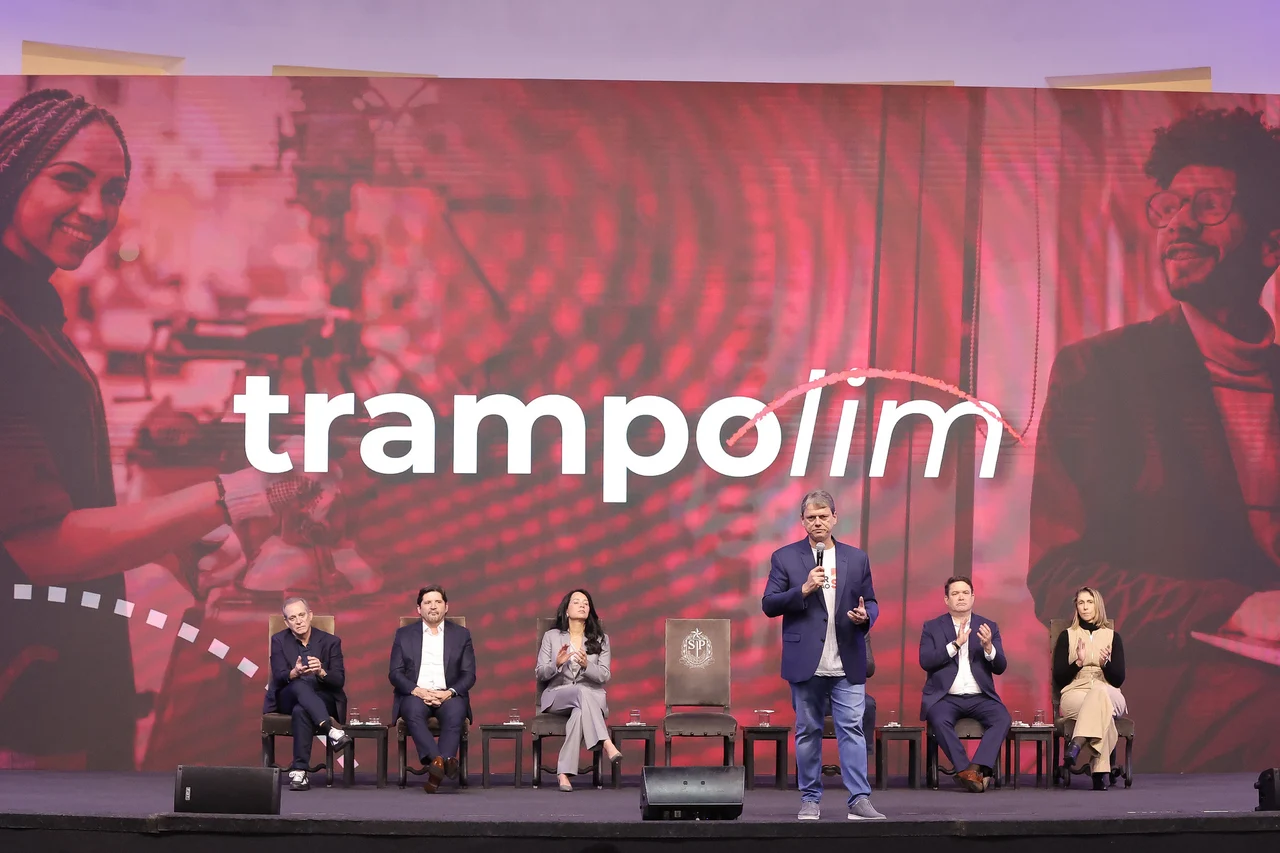 Autoridades no palco de lançamento do Trampolim, diante de um painel com o nome do programa.